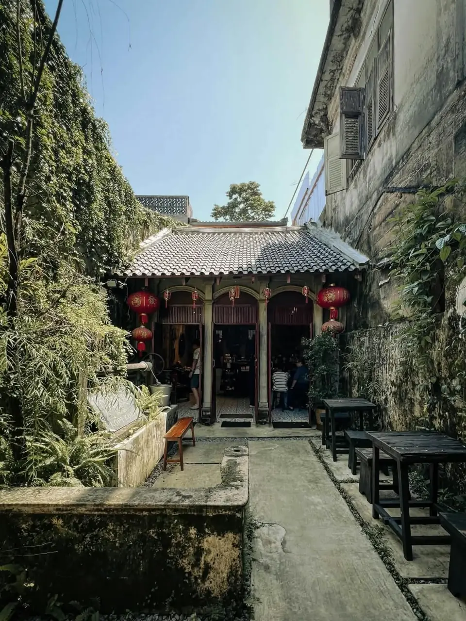 Shaded courtyard beside an old Takua Pa building