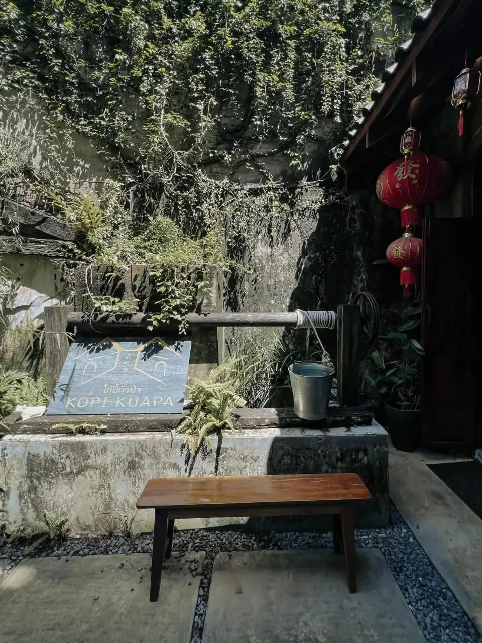 Shaded courtyard beside an old Takua Pa building