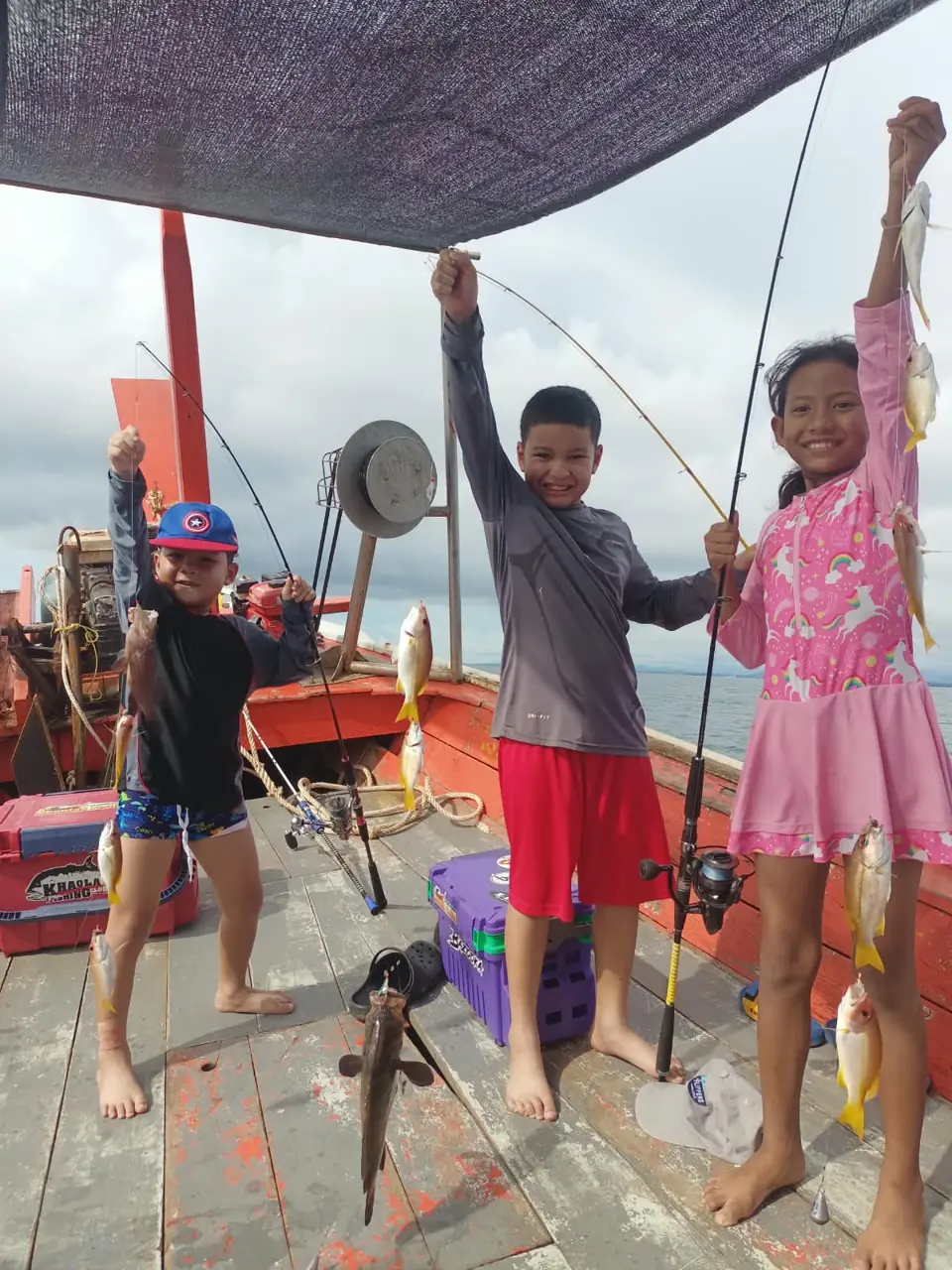 Guests showing their catch together aboard the fishing boat